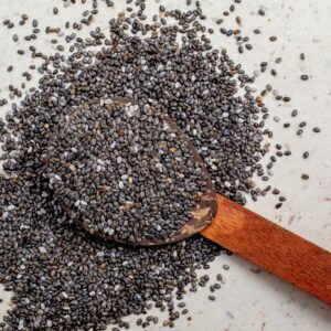 Wooden spoon filled with chia seeds, highlighting their texture and nutritional value.